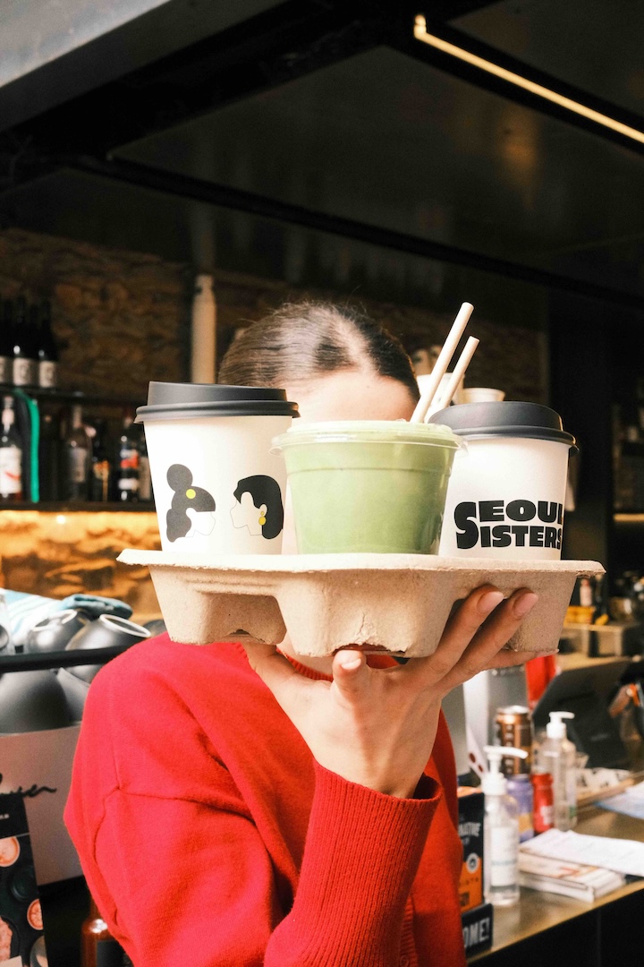 Girl holding takeaway drinks on a tray